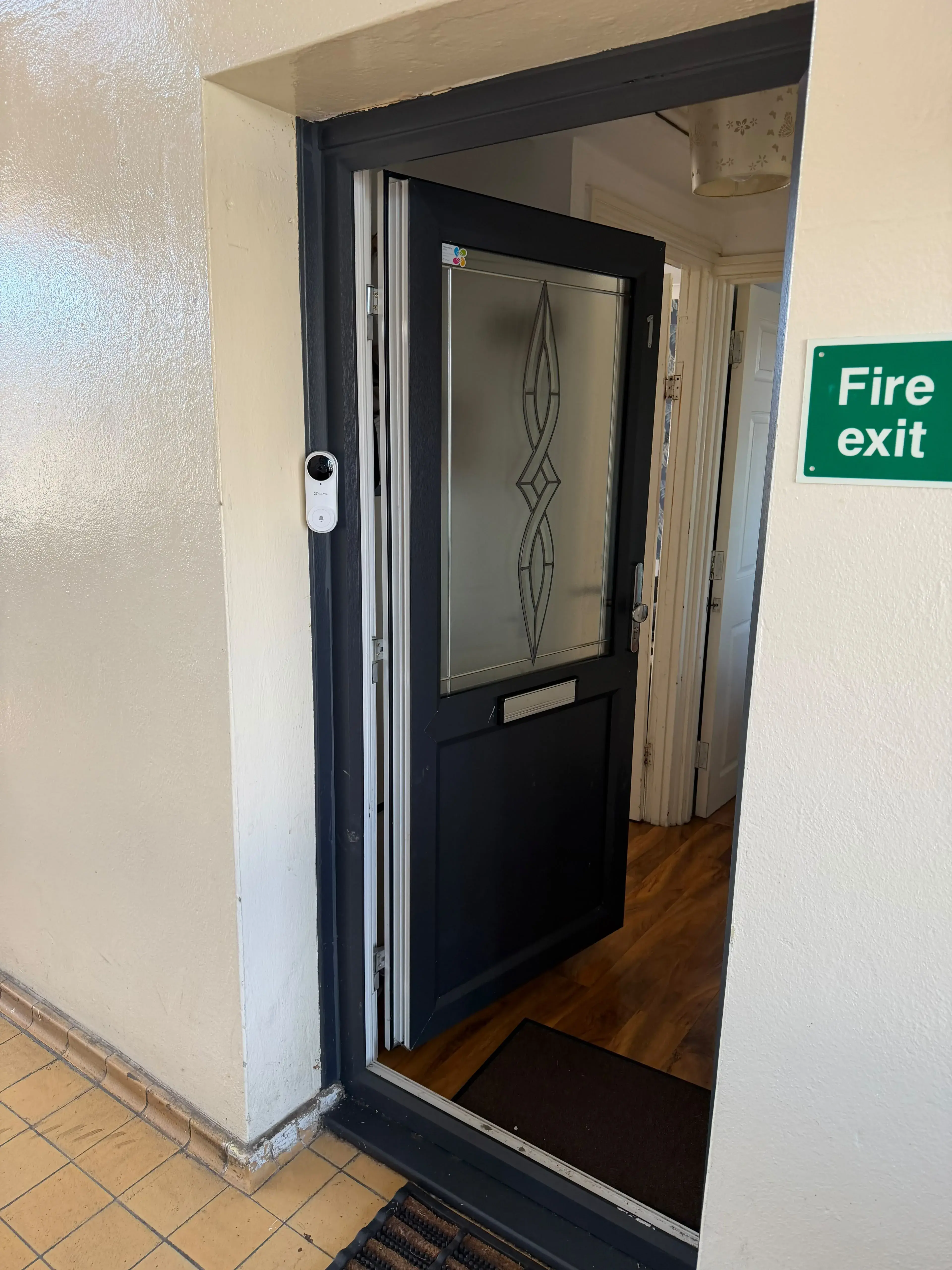 Video doorbell installed beside a communal entrance door