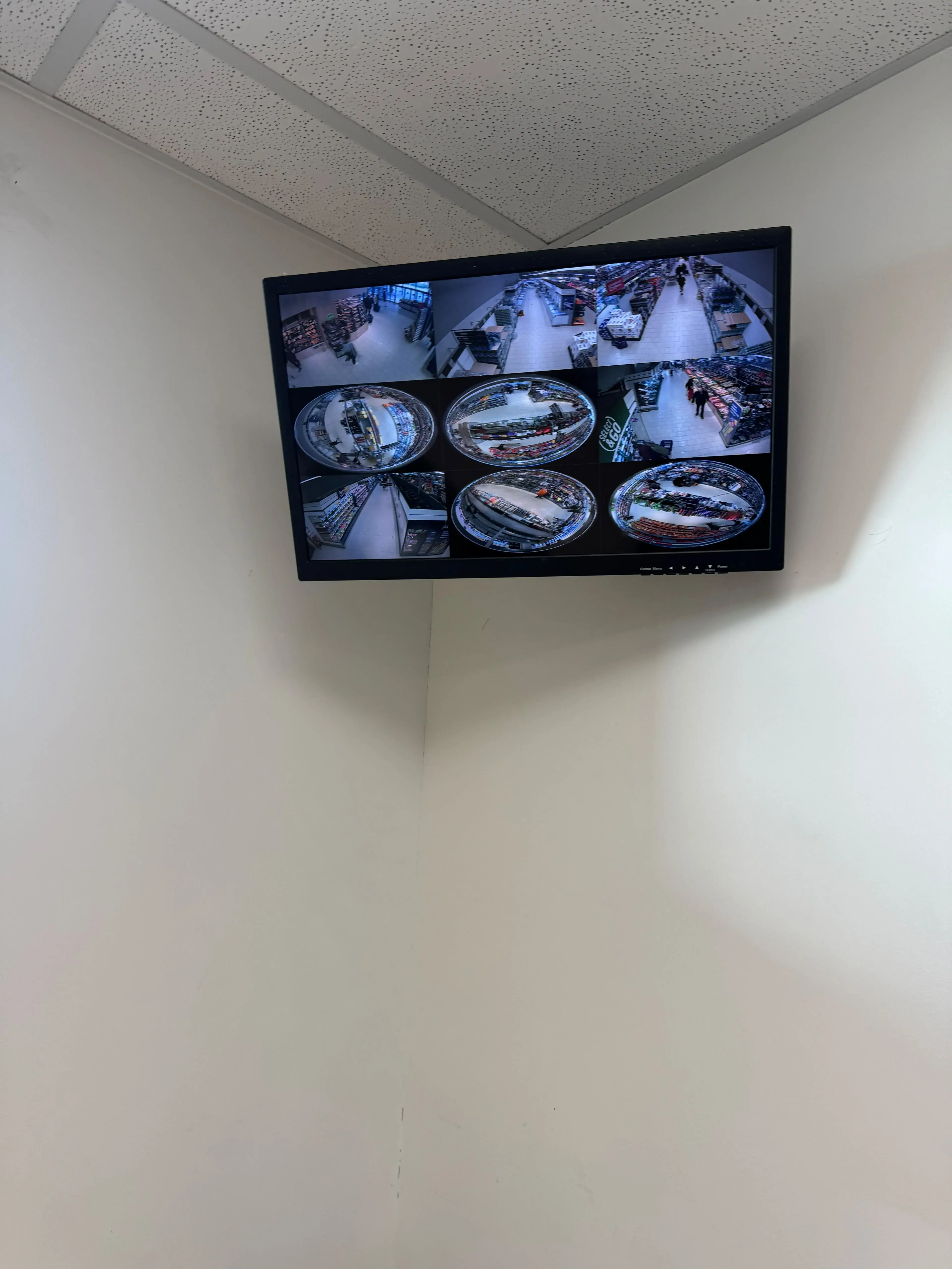 Wall-mounted shop CCTV monitor showing fisheye camera views