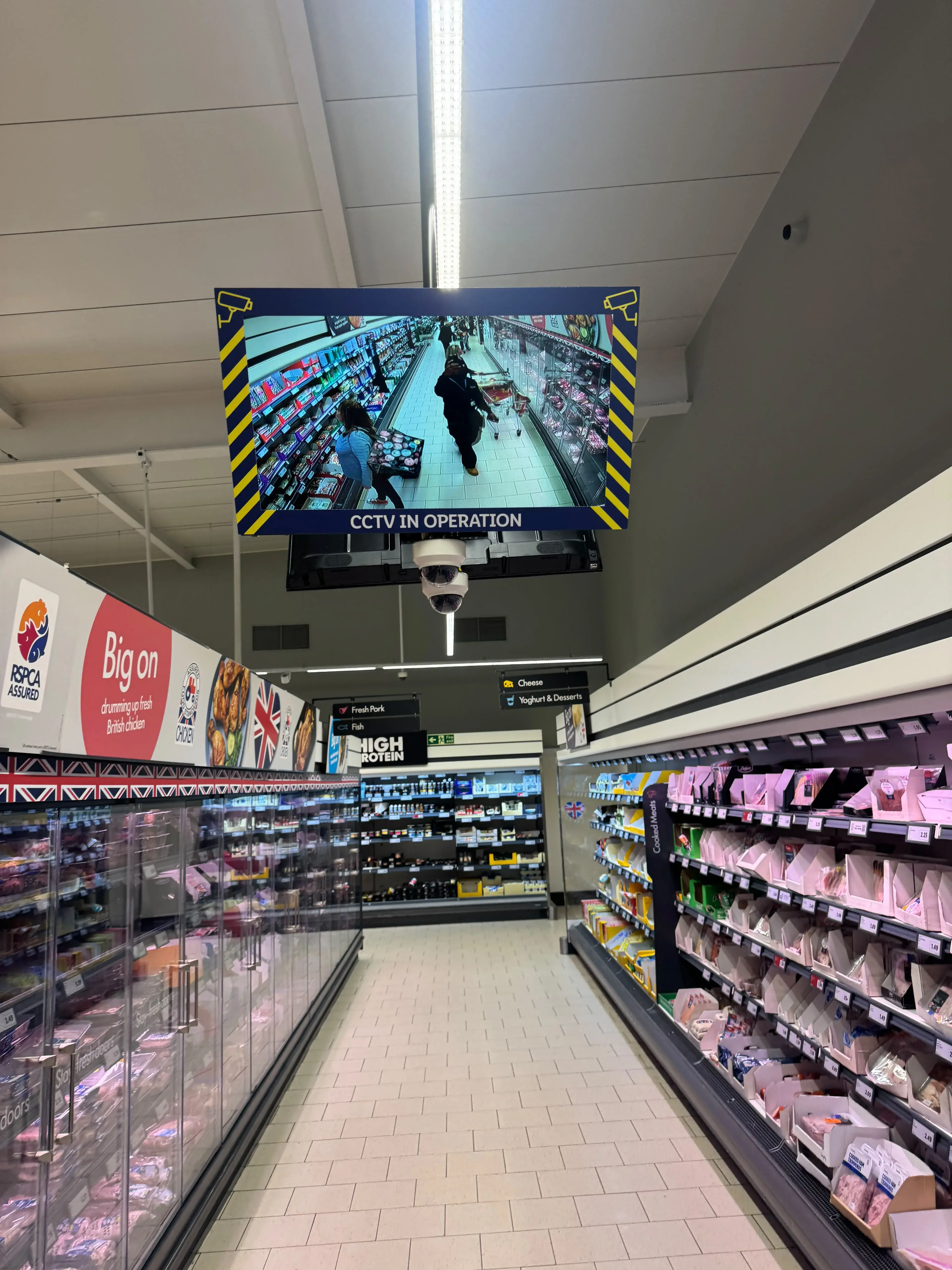 Public view CCTV monitor above a supermarket aisle