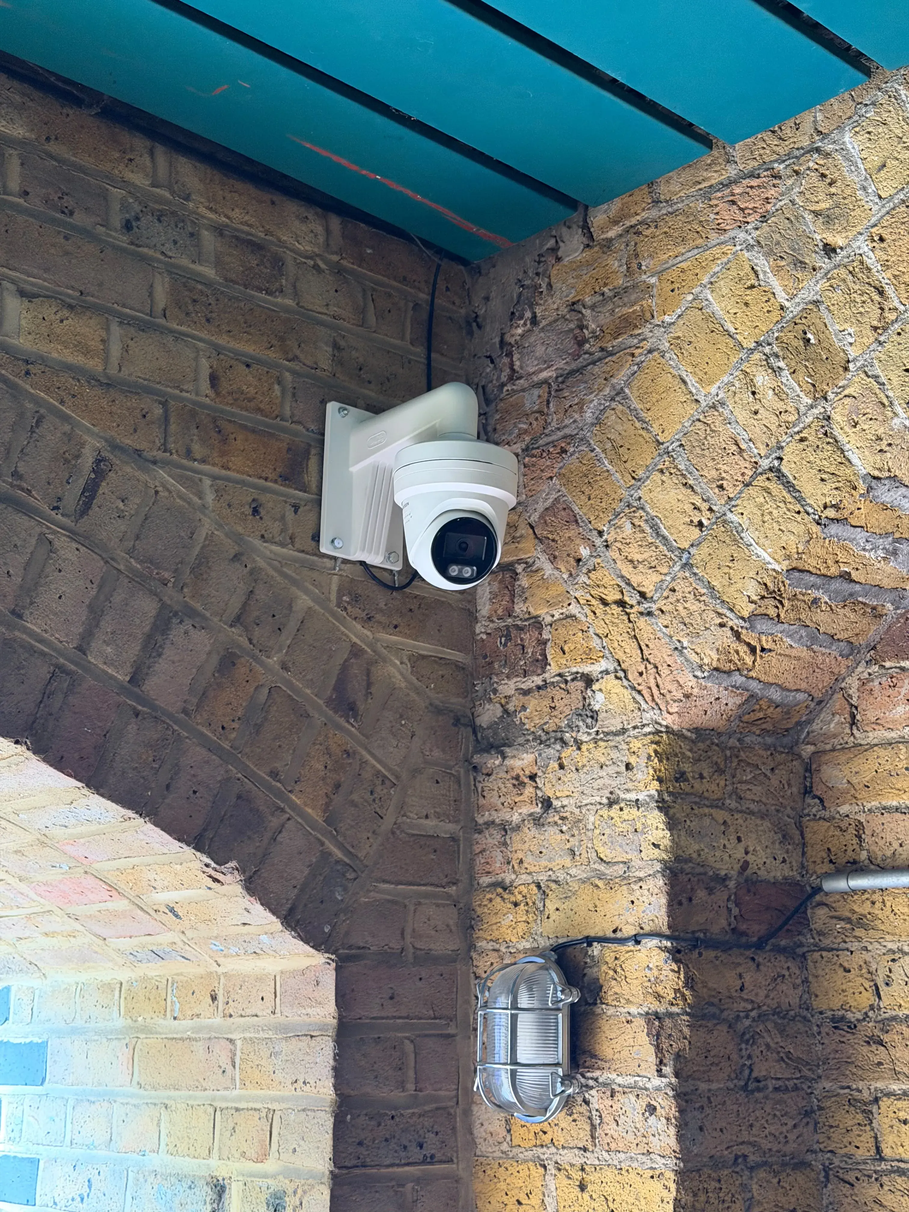 Turret CCTV camera fitted in a brick archway corner