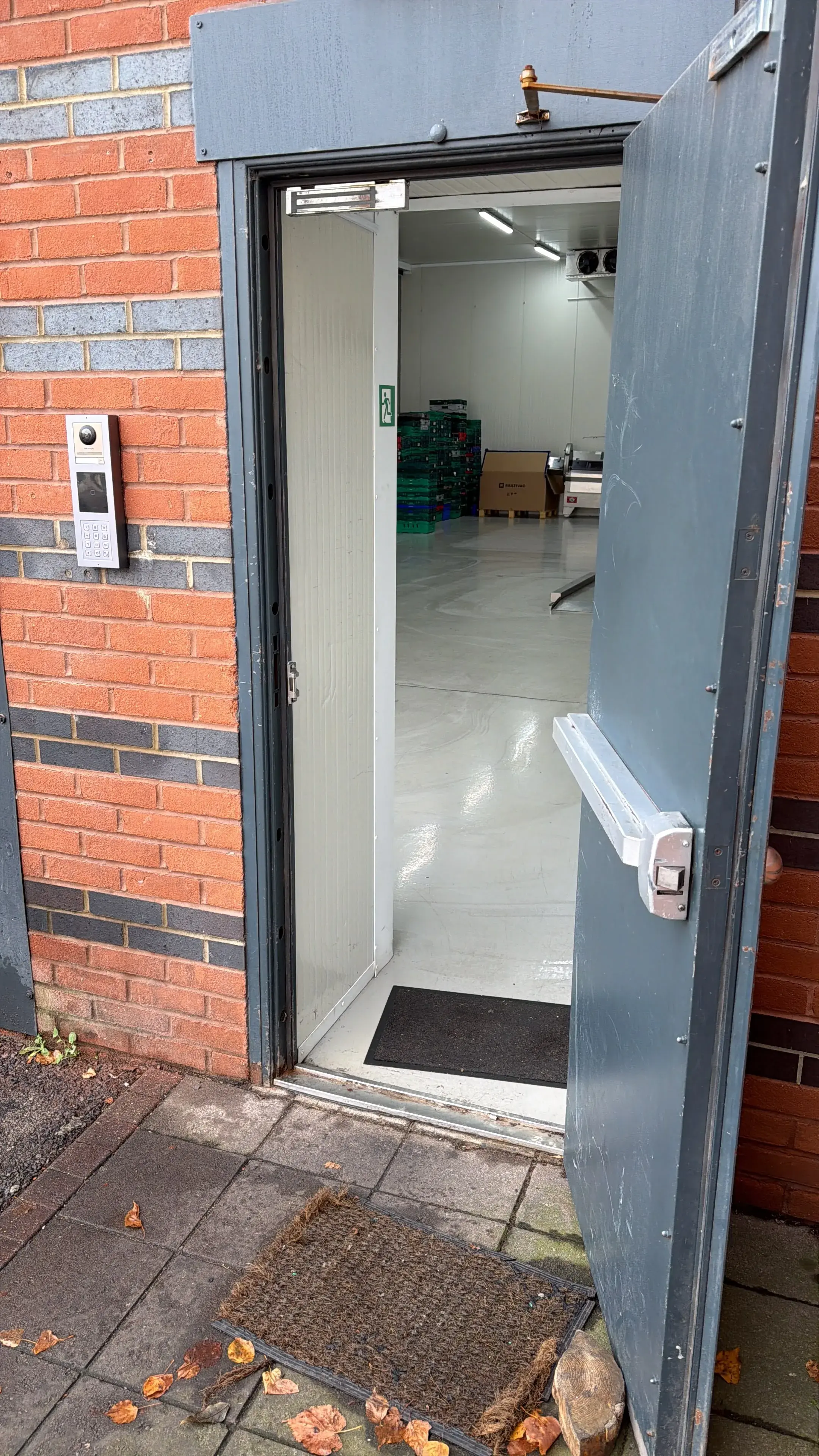 Door entry intercom panel fitted beside a warehouse door